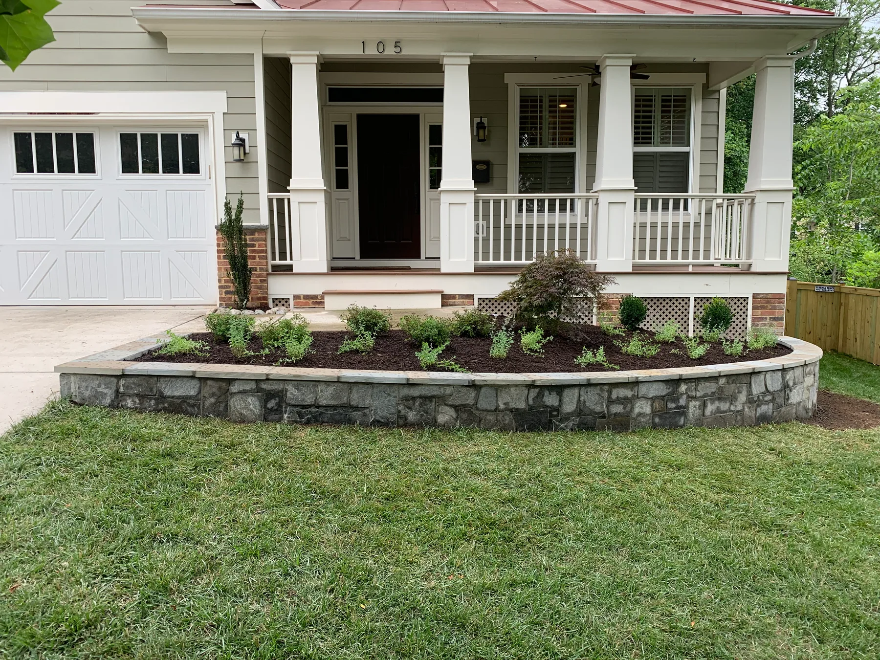 Colorful planting bed along a natural stone wall